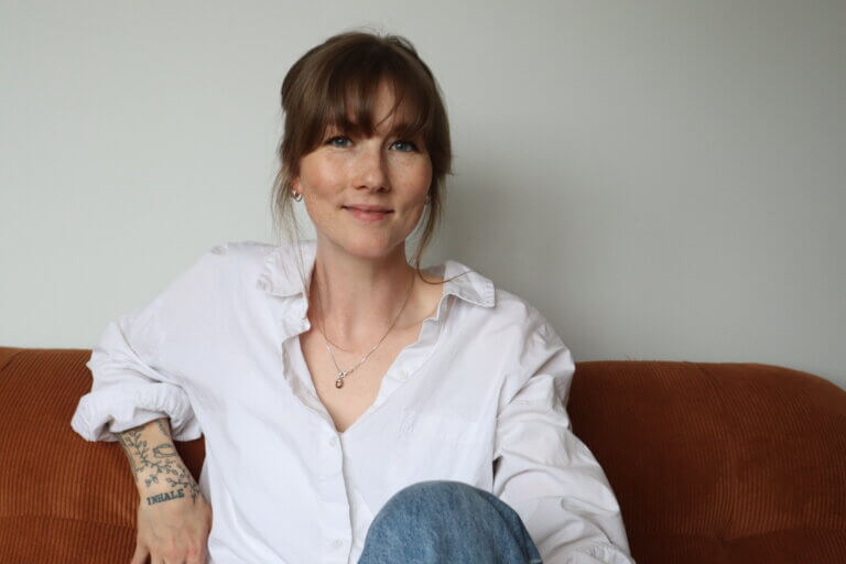 Mia Andersson, livscoach, sitter lugnt i en soffa och reflekterar kring stress och inre lugn
