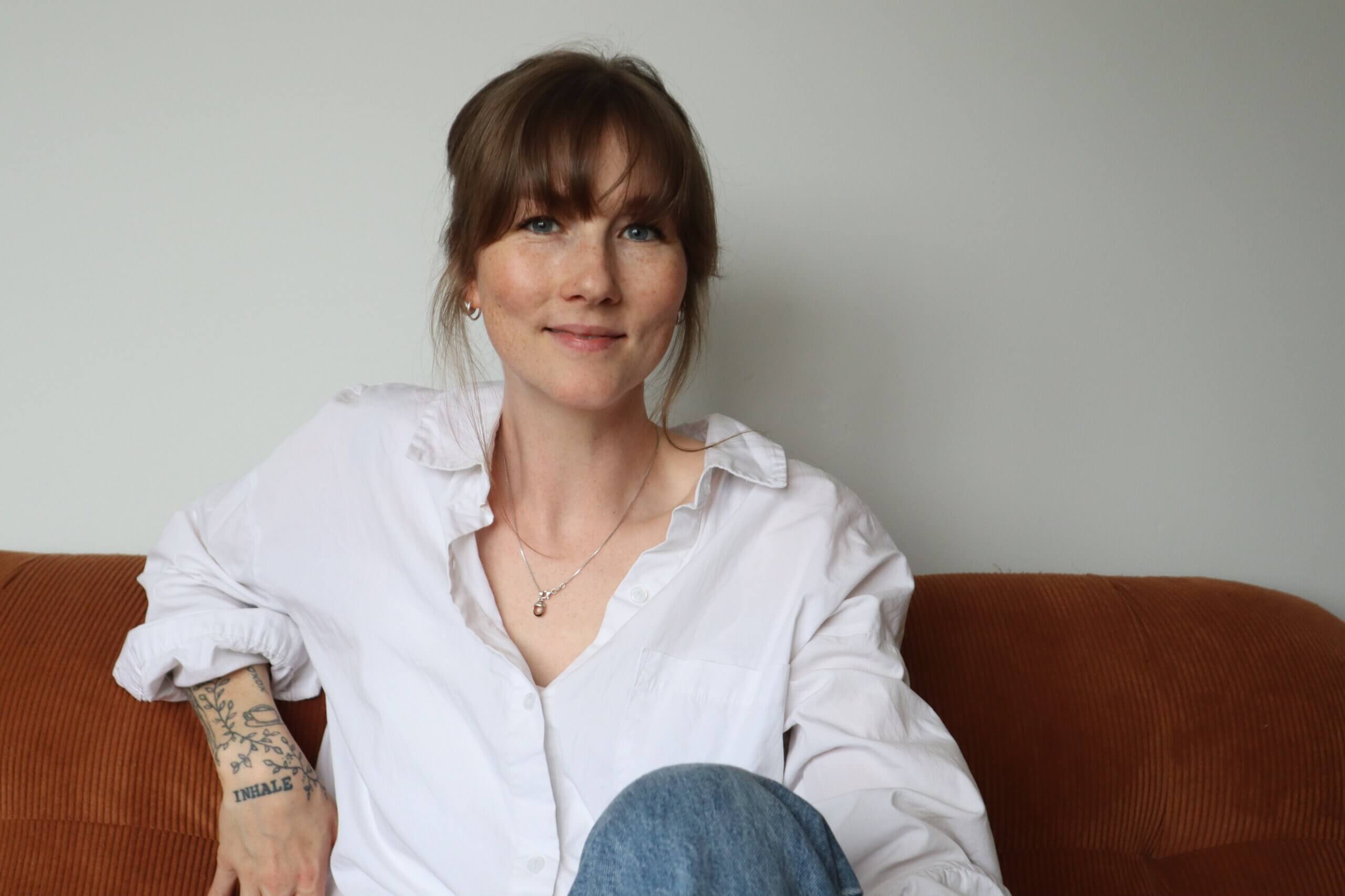 Mia Andersson, livscoach, sitter lugnt i en soffa och reflekterar kring stress och inre lugn