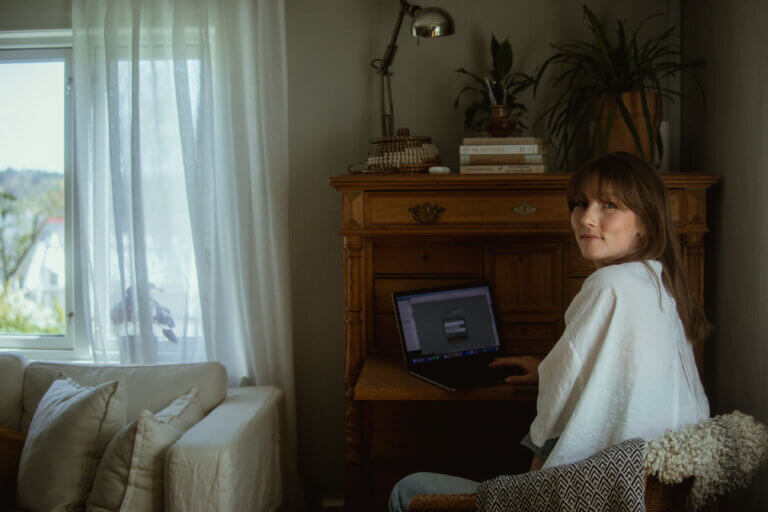 kvinna sitter vid skrivbord och tar en paus